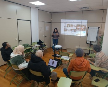 una mujer explica cómo hacer búsqueda en los navegadores a un grupo de personas en un aula