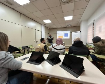 clase de digitalización con tables a un grupo de personas diversas